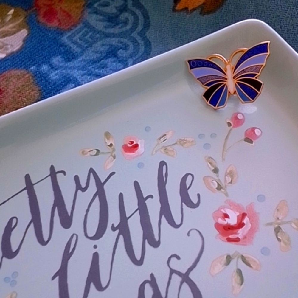 Cloisonne-style butterfly pin in blue, black, and white with gold metal …